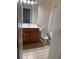 Bathroom with wood vanity, white sink, toilet, and tile flooring at 5467 Soapstone Pl # 203, Sarasota, FL 34233