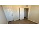Bedroom with laminate flooring, open closet doors, and neutral paint at 5467 Soapstone Pl # 203, Sarasota, FL 34233