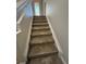 Carpeted staircase to the upper level at 5467 Soapstone Pl # 203, Sarasota, FL 34233