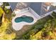 Aerial view of a home with a kidney-shaped pool and paved patio at 566 Oak Bay Dr, Osprey, FL 34229