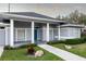 Gray house with blue door, columned porch, and landscaped yard at 566 Oak Bay Dr, Osprey, FL 34229