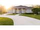 Gray house with blue door, columned porch, and landscaped yard at 566 Oak Bay Dr, Osprey, FL 34229