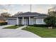 Gray house with blue door, columned porch, and landscaped yard at 566 Oak Bay Dr, Osprey, FL 34229