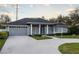 Gray house with blue door, columned porch, and landscaped yard at 566 Oak Bay Dr, Osprey, FL 34229