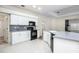 Kitchen with white cabinets, black appliances, and island at 566 Oak Bay Dr, Osprey, FL 34229