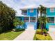 Two story home with blue exterior and paved driveway at 7007 Holmes Blvd, Holmes Beach, FL 34217