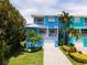 Two story home with blue exterior and paved driveway at 7007 Holmes Blvd, Holmes Beach, FL 34217