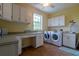 Bright laundry room with washer, dryer, and ample storage at 7007 Holmes Blvd, Holmes Beach, FL 34217