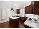 Well-equipped kitchen with island, dark wood cabinets, and white countertops at 801 Longboat Club Rd, Longboat Key, FL 34228