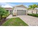 Single-story home with gray siding, stone accents, and a paved driveway at 8792 Rain Song Rd, Sarasota, FL 34238