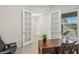 Bright home office with built-in desk and French doors at 8792 Rain Song Rd, Sarasota, FL 34238