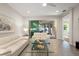 Open living room showcasing a glass-top coffee table and access to a private patio at 8792 Rain Song Rd, Sarasota, FL 34238