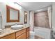 Bathroom featuring a granite countertop, wood cabinets, and a shower with decorative tile at 9393 Midnight Pass Rd # 201, Sarasota, FL 34242