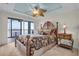 Comfortable bedroom features a unique ceiling fan and a balcony view at 9393 Midnight Pass Rd # 201, Sarasota, FL 34242