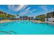 Inviting community pool with lounge chairs and umbrellas at 1055 Gulf Of Mexico Dr # 504, Longboat Key, FL 34228