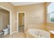 Spacious bathroom featuring soaking tub, tile flooring, and separate toilet area at 12342 Lavender Loop, Bradenton, FL 34212