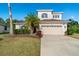 Inviting front yard with palm trees and a paved driveway leading to a two-story home at 12342 Lavender Loop, Bradenton, FL 34212