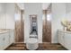 Modern bathroom with dual vanities, walk-in shower, tile walls, and wood-look floor at 1256 Napoleon Rd, North Port, FL 34288