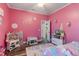 Whimsical pink bedroom with two beds, personalized decor, and a play area at 1256 Napoleon Rd, North Port, FL 34288
