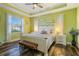 Green bedroom with white furniture, ceiling fan, and wood-look flooring at 1256 Napoleon Rd, North Port, FL 34288