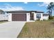 Inviting home exterior with a brown double garage, manicured landscaping, and a concrete driveway at 1256 Napoleon Rd, North Port, FL 34288