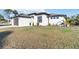 Exterior view of a single-story home with a brown garage door, landscaping, and a large front lawn at 1256 Napoleon Rd, North Port, FL 34288