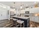 Bright and airy kitchen featuring white cabinets, an island with seating, and wood-look tile floors at 1256 Napoleon Rd, North Port, FL 34288
