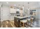 Modern kitchen featuring white cabinets, a large island, and wood-look flooring at 1256 Napoleon Rd, North Port, FL 34288