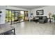 Living room with tiled floors, sectional sofa, and screened patio access at 1700 Cove Ii Pl # 311, Sarasota, FL 34242
