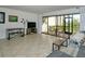 Living room with tiled floors, sectional sofa, and screened patio access at 1700 Cove Ii Pl # 311, Sarasota, FL 34242
