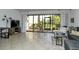 Living room with tiled floors, sectional sofa, and screened patio access at 1700 Cove Ii Pl # 311, Sarasota, FL 34242