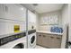 Well-equipped laundry room with a stacked washer and dryer, counter space, and storage cabinets at 200 Garfield Dr, Sarasota, FL 34236