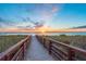 Scenic boardwalk leading to a beautiful sandy beach with a vibrant sunset view at 2050 Benjamin Franklin Dr # B603, Sarasota, FL 34236