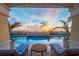 Tranquil pool area with lounge chairs, a table, and a view of the sunrise over the ocean at 2050 Benjamin Franklin Dr # B603, Sarasota, FL 34236