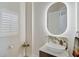 Stylish powder room with an illuminated oval mirror and marble vanity at 2112 Calusa Lakes Blvd, Nokomis, FL 34275