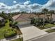 Exterior view of single-Gathering home with tile roof, three-car garage, and palm trees at 2112 Calusa Lakes Blvd, Nokomis, FL 34275