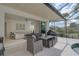 Covered patio with seating area adjacent to the living room and pool at 2112 Calusa Lakes Blvd, Nokomis, FL 34275