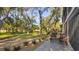 Tranquil backyard with patio, mature trees, and community pathway at 3029 Quail Holw # 15, Sarasota, FL 34235