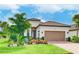Charming home featuring a well-manicured lawn, decorative front garden, and a two-car garage at 4707 Arpino Ct, Bradenton, FL 34211