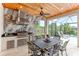 Elegant outdoor kitchen with stainless steel appliances and seating for six at 4707 Arpino Ct, Bradenton, FL 34211