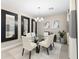 Modern dining room with glass table, white chairs, and statement mirrors at 4905 Avila Lakes Dr, Wimauma, FL 33598