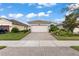 Single-story home with a two-car garage and landscaped front yard at 4905 Avila Lakes Dr, Wimauma, FL 33598
