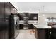 Modern kitchen with dark cabinets, stainless steel appliances and granite countertops at 4905 Avila Lakes Dr, Wimauma, FL 33598