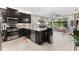 Open concept kitchen with island, stainless steel appliances, and view into living room at 4905 Avila Lakes Dr, Wimauma, FL 33598