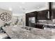 Spacious kitchen boasts dark cabinetry, granite countertops, and stainless steel appliances at 4905 Avila Lakes Dr, Wimauma, FL 33598