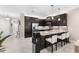 Modern kitchen with dark cabinets, granite counters, and stainless steel appliances at 4905 Avila Lakes Dr, Wimauma, FL 33598