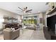 Relaxing living room with sliding doors leading to a patio and a large TV at 4905 Avila Lakes Dr, Wimauma, FL 33598