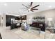 Open living area with a ceiling fan, leather sofas, and views of the backyard at 4905 Avila Lakes Dr, Wimauma, FL 33598