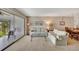 Living room with white sofas, glass coffee table, and sliding glass doors to a porch at 6029 E Peppertree Way # 116, Sarasota, FL 34242