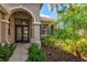 Elegant front entry with arched doorway, double doors, and manicured landscaping at 608 Misty Pond Ct, Bradenton, FL 34212